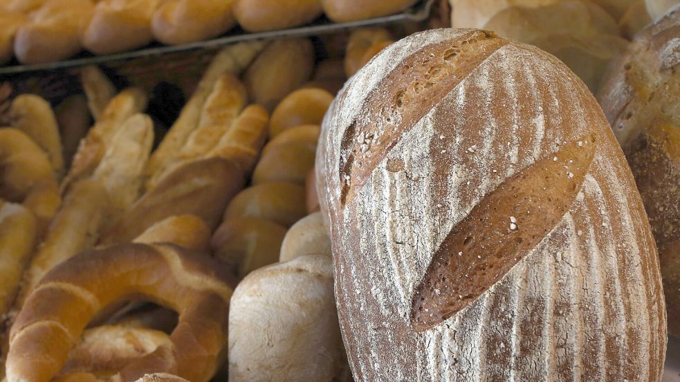Ein Brot, Brötchen und Hörnchen liegen in der Auslage eines Bäckers. Foto: Karl-Josef Hildenbrand/DPA