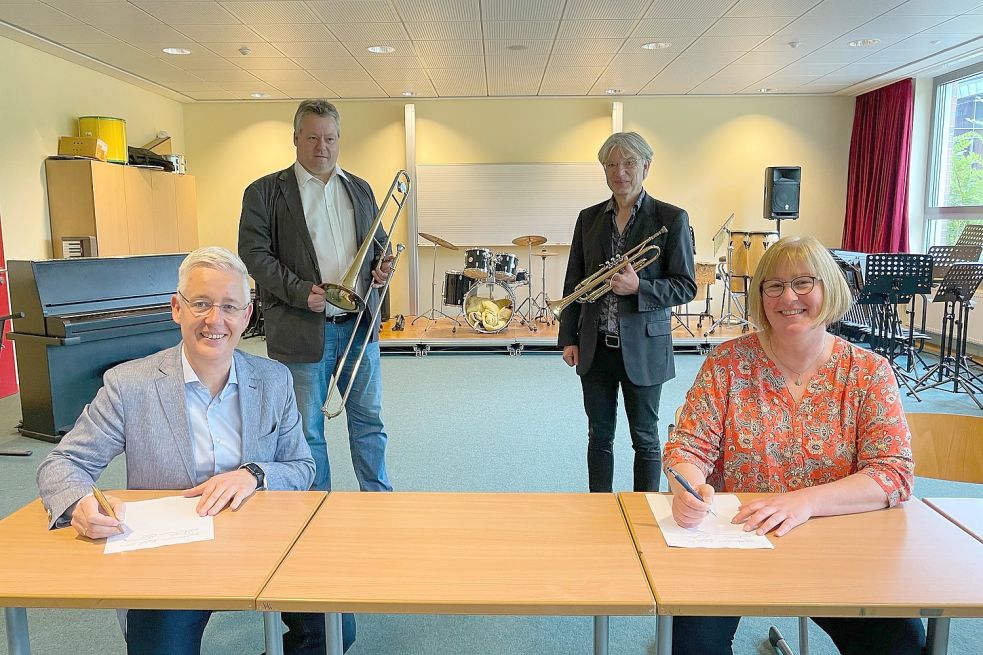Das Bild zeigt Schulleiterin Ulrike Janssen und Landrat Matthias Groote (von links) bei der Vertragsunterzeichnung sowie Kreismusikschulleiter Stefan Leja und Musiklehrer Hans-Joachim Trum. Foto: Landkreis Leer