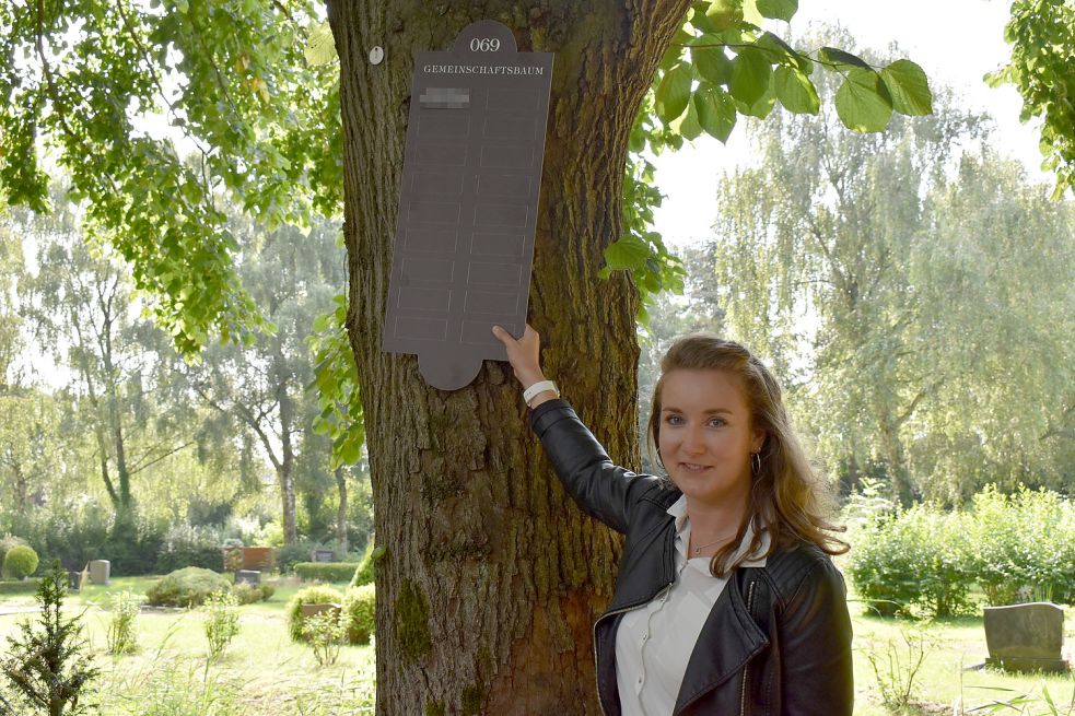 Anna Macknow vom Bau- und Entsorgungsbetrieb zeigte die Plakette, die an den Bäumen angebracht werden soll.