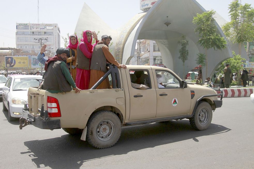Taliban-Kämpfer sitzen auf der Ladefläche eins Pick-ups. Die militant-islamistischen Taliban setzen ihren Vormarsch in Afghanistan fort, am Sonntag erreichten sie Kabul. Foto: Sarfarazi/AP/dpa