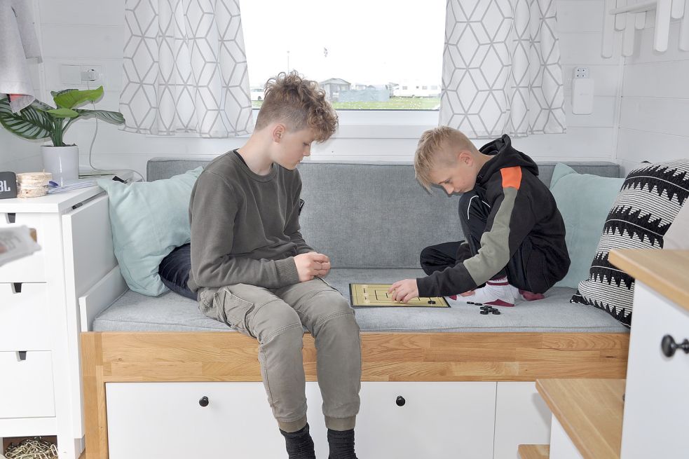 Nachts ein Bett, tagsüber ein Sofa zum Abhängen oder Spielen. Mats Artmeyer (links) und Mattis Arndt zeigen, wie man den wenigen Platz in einem Tiny House optimal nutzt. Foto: Ullrich