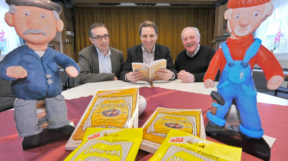 2015 erschien der erste Band mit Joke & Harm. Die Bücher sind dem Design der "Echten Emder"-Bonbons nachempfunden. Hersteller ist die Firma Opifera, bei der Buchvorstellung damals vertreten durch Thorsten Renken von der Firma Domsky (links), hier mit Lübbert Haneborger und Jakob Janshen vom Heimatverein Oldersum. Foto: Ortgies/Archiv