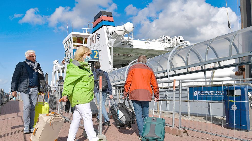 Fährgäste im Hafen von Norddeich auf dem Weg zum Schiff. Die Verbindung nach Norderney ist die günstigste im Vergleich aller Ostfriesischen Inseln. Im Vergleich zu den Niederlanden ist es teuer. Foto: Ortgies