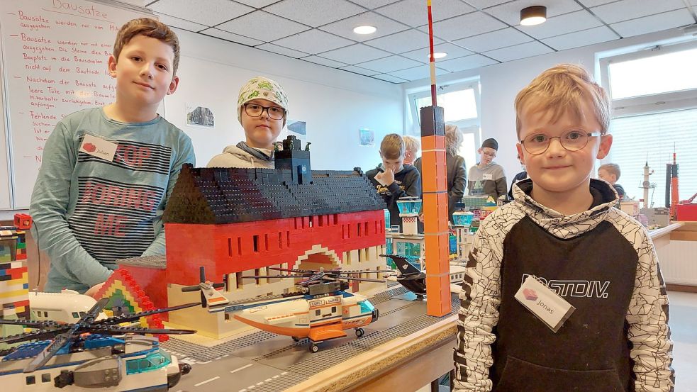 Julian (von links) und Luca haben gemeinsam das Emder Rathaus nachgebaut. Jonas hat den höchsten Turm der Lego-Stadt geschaffen. Fotos: Hanssen