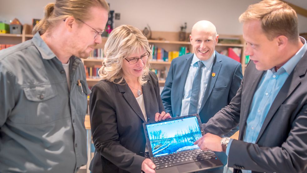 Ein rein symbolisches Bild: Stellvertretend fürs Geld, das größtenteils über das Land vom Bund nach Großefehn geflossen ist, überreichte der SPD-Landtagsabgeordnete Wiard Siebels (von rechts) einen Laptop an Bürgermeister Erwin Adams, die EDV-Chefin der Gemeinde, Karin Juilfs, und den Strackholter Grundschulleiter Andreas Moritz. Foto: Cordsen