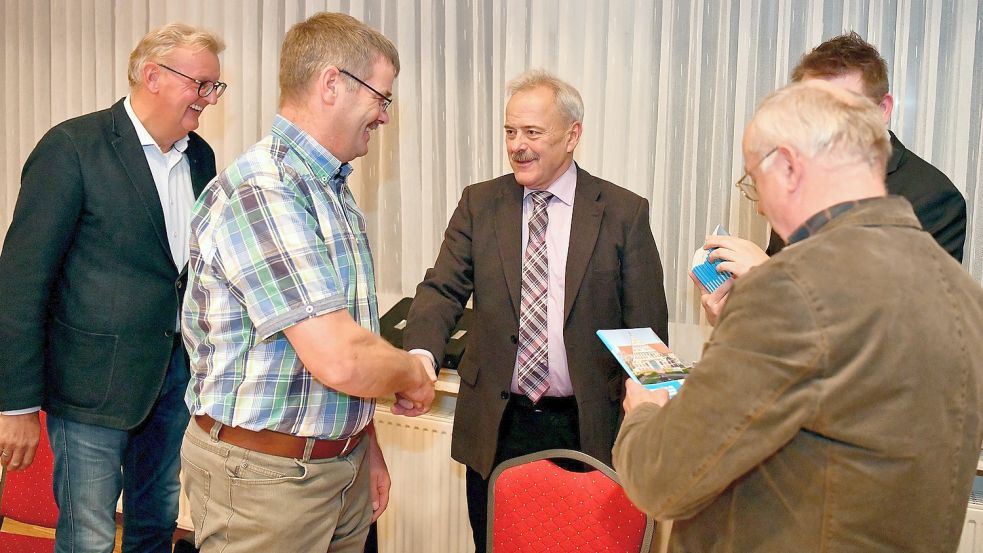 Samtgemeindebürgermeister Uwe Themann (Mitte) und der Allgemeine Vertreter Joachim Duin (verdeckt) verpflichteten alle neuen Ratsmitglieder, hier (von links) Johannes Poppen (AWG), Erwin Burlager (AWG) und Bernhard Janssen (AWG). Foto: Stromann