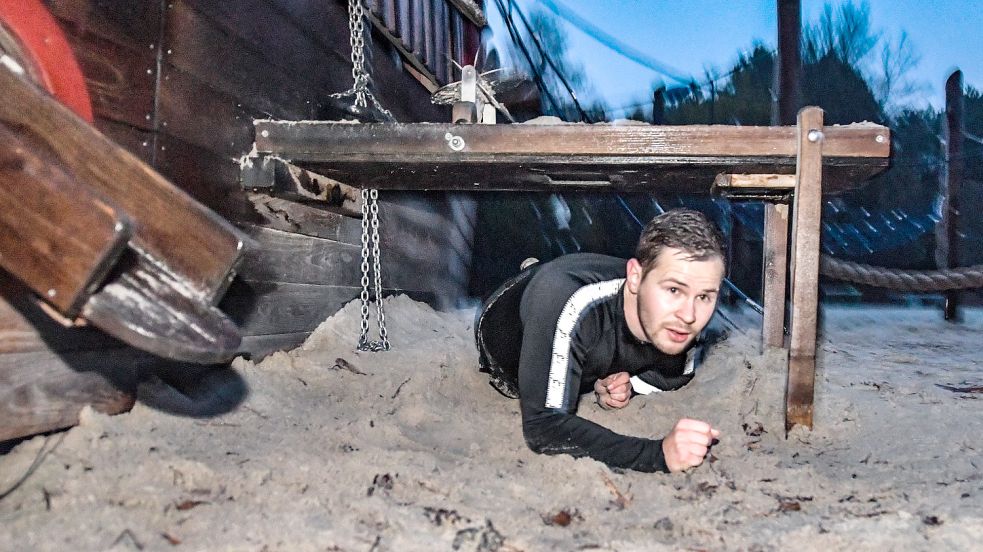 Für Übungen nutzen die Wiesmoorer Extremsportler alles , was sie so begegnen. Der Strand am Ottermeer bietet mit einem Spielplatz da so einiges – zum Rüberspringen, Gegentreten und wie hier zum Drunterdurchkriechen. Fotos: Ortgies
