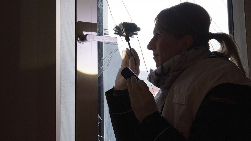 Eine Kriminaloberkommissarin beim Kriminaldauerdienst der Polizei Hannover sichert nach einem Einbruch Spuren an einer eingeschlagenen Fensterscheibe. Foto: Stratenschulte/dpa