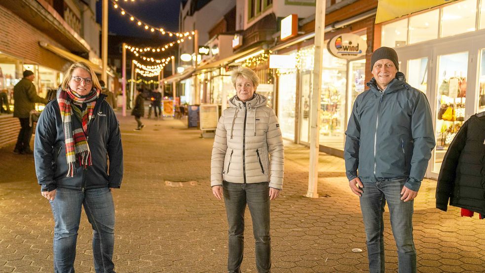 Endlich zieren die obere Franz-Habich-Straße wieder weihnachtliche Lichter. Von links: Pia Hosemann, Kirsa Tebbens vom Sporthaus Tebbens und Jürgen Akkermann. Foto: Behr/NBG