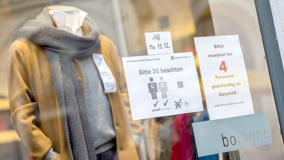 Auf die 2G-Regelung wird an einem Schaufenster eines Geschäftes in der Oldenburger Fußgängerzone hingewiesen. Foto: Mohssen Assanimoghaddam/dpa