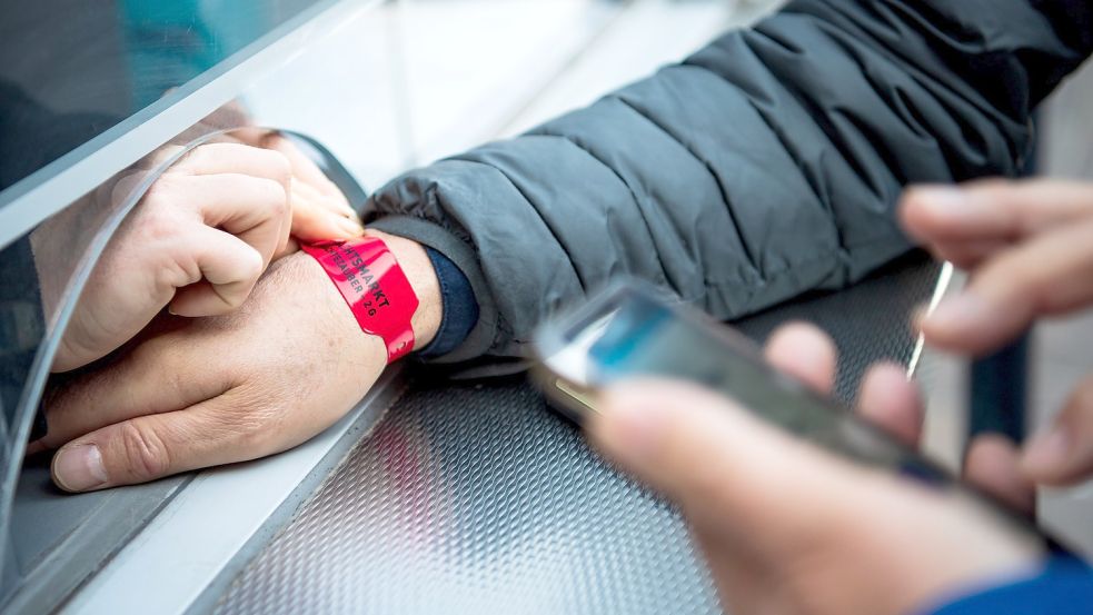 Insulaner und Borkumurlauber erhalten ab Montag, wie auf diesem Symbolfoto, ein Bändchen, das ihren jeweiligen Impf- oder Genesenennachweis farbig anzeigt. Foto: Schuldt/dpa