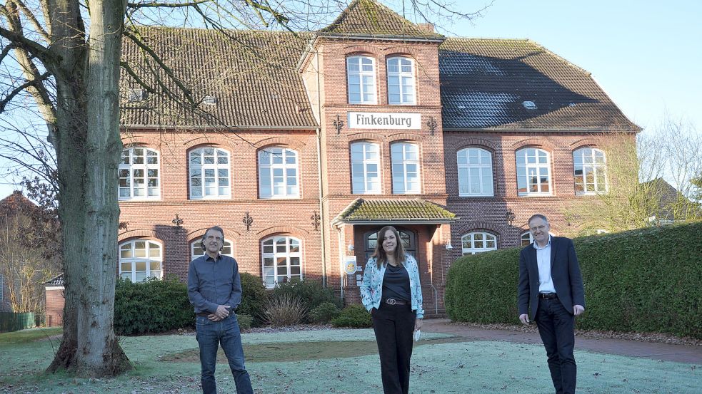 Ralf Mrutzek (von links) und Dagmar Keuenhof mit Uwe Cassens vor der historischen Fassade der alten Schule. Foto: Ullrich