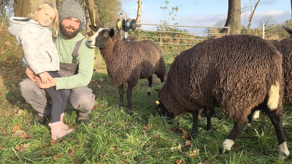 Landwirt Hilmar Wolters, hier mit Töchterchen Santje, kontrolliert jetzt noch öfters als ohnehin schon seine Schafweiden. Foto: Schneider-Berents