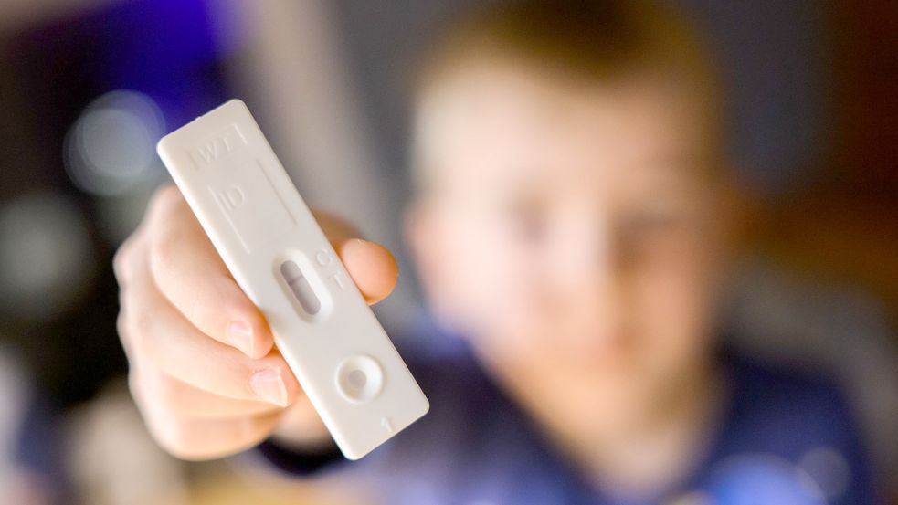 Ein fünfjähriger Junge zeigt einen negativen Corona-Selbsttest (gestellte Szene). Ab diesem Dienstag gibt es in Niedersachsen eine Corona-Testpflicht für Kitas. Kinder ab drei Jahren müssen dann künftig dreimal wöchentlich negativ getestet sein, um eine Kita besuchen zu können. Foto: Julian Stratenschulte/dpa