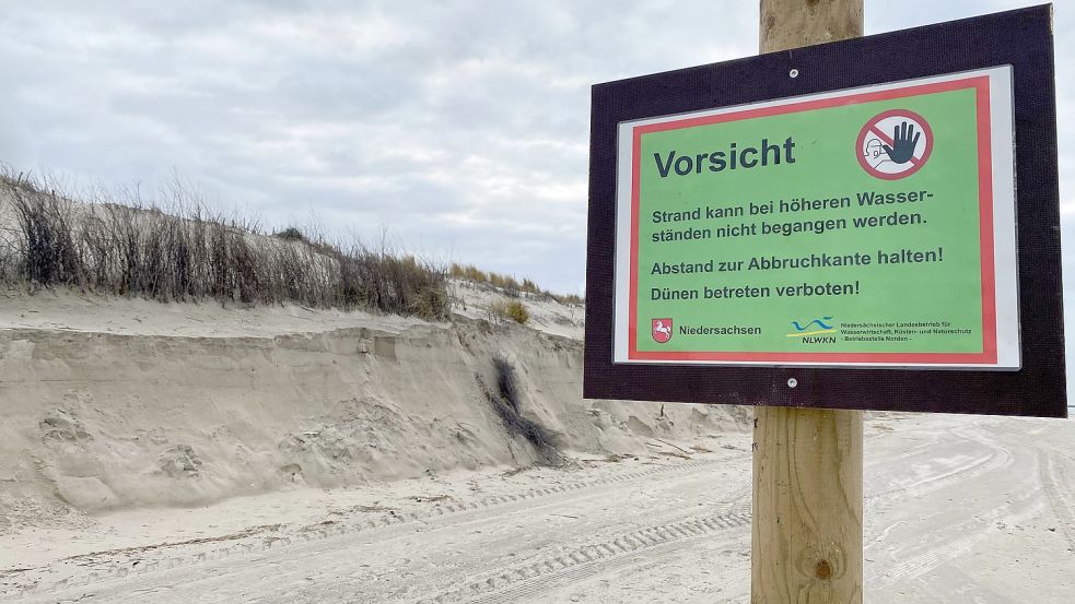 An einer Dünenabbruchkante auf der Insel Norderney warnt ein Schild des Niedersächsischen Landesbetriebs für Wasserwirtschaft, Küsten- und Naturschutz (NLWKN) Spaziergänger vor dem Betreten eines Strandabschnittes bei Hochwasser. DPA-Foto: Bartels