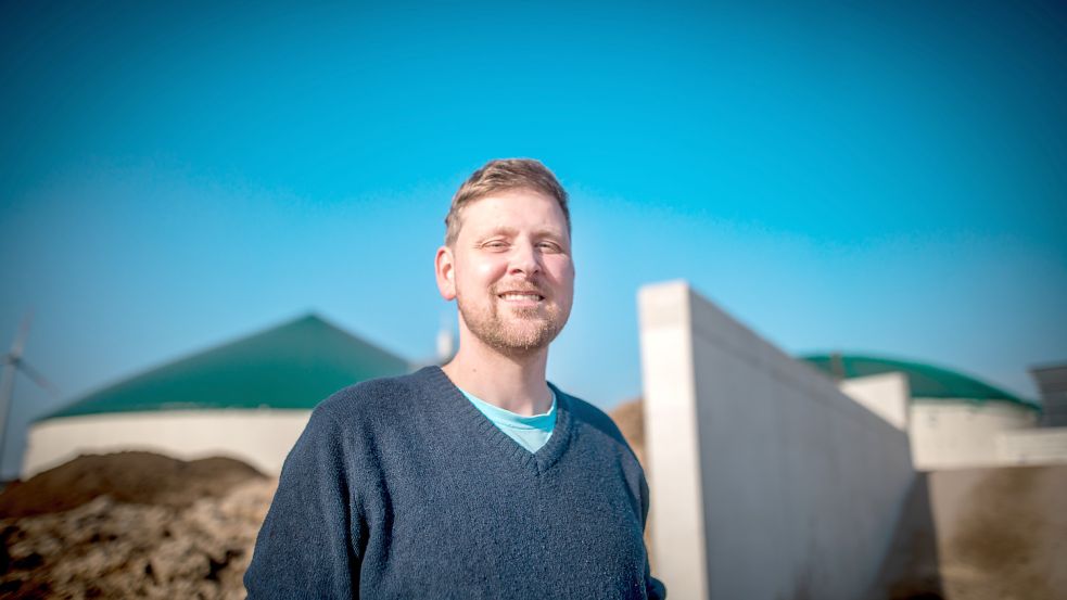 Ingo Lenz an seinem "Güllekraftwerk". Links im Hintergrund ist der Ablageplatz für den festen Wirtschaftsdünger zu sehen, der nach der Vergärung aus der Anlage gepresst wird. Foto: Cordsen