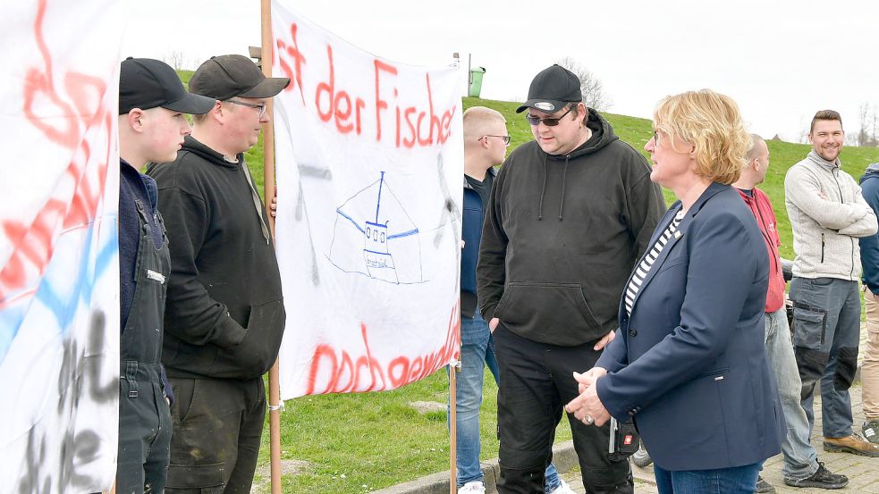 Fischereiministerin Barbara Otte-Kinast sprach bei ihrem Besuch in Greetsiel mit Fischern, die mit Bannern im Hafen auf die enorm gestiegenen Dieselpreise aufmerksam machten. Foto: H. Wagenaar