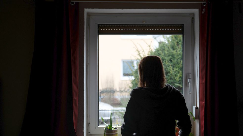 Frau schaut während ihrer Isolation aus dem Fenster Foto: dpa / Sebastian Gollnow