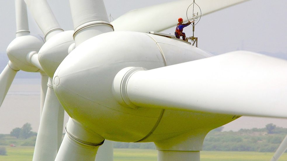 Extra außen auf die Anlagen klettern, wie dieser Techniker beim Justieren des Windmessgerätes auf einem Enercon-Windkraftrad, mussten die Enercon-Arbeiter für den Modemtausch nicht. Doch mussten sie jede Anlage mit kaputter Technik einzeln anfahren und Geräte tauschen. Foto: Wagner/DPA