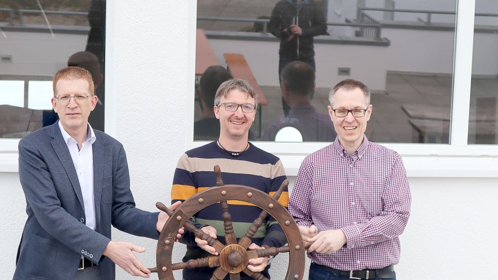 Nach erfolgreicher Arbeit übergibt Architekt Andreas Otte (Mitte) symbolisch das Steuerrad der MS Waterdelle an Hausleiter Schneider (rechts) und CVJM-Generalsekretär Hansjörg Kopp (links).
