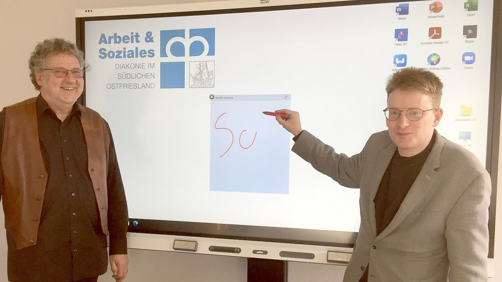 Alf Wehmhörner, Geschäftsführer der Arbeit & Soziales gem. GmbH (links), und Carl-Hermann Ackermann, Leiter der Hafenschule, führen ein neues Smartboard vor. Foto: Mielcarek