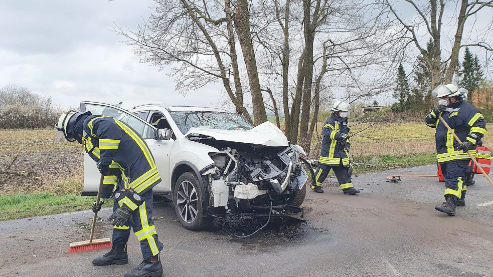 Feuerwehrleute reinigten nach dem Unfall die Fahrbahn der Stapelmoorer Straße in Holthusen. Bild: Gettkowski