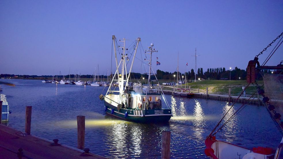 Ein Kutter verlässt abends Greetsiel: Die Schiffe gehören klar zum Krummhörner Fischerdorf, ein Wahrzeichen aber sind sie in der Menge nicht.