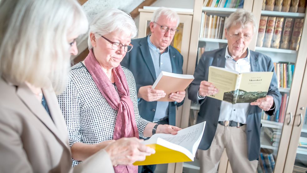 Hilde Krull-Trauernicht (von links), ihre Geschwister Theda und Johannes sowie Museumsvorstand Hinrich Tjaden blätterten zur feierlichen Schenkung der Sammlung in Werken aus dem Nachlass. Foto: Cordsen
