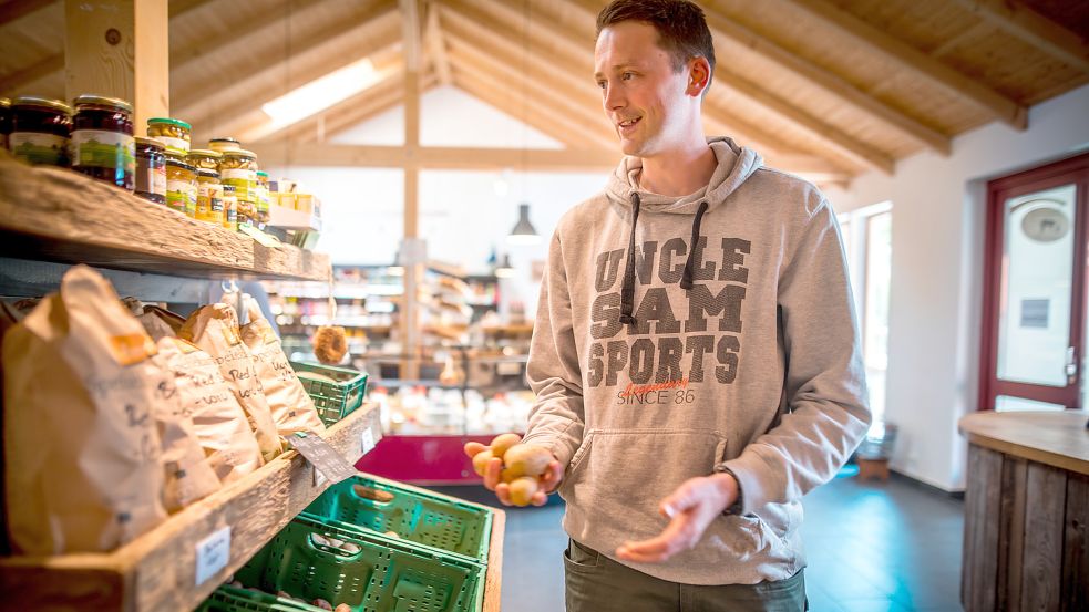 2014 hat Familie Caspers mit einem winzigen Hofladen begonnen. Seit 2019 gibt es einen großen Neubau für die Direktvermarktung der Produkte – unter anderem eigene Kartoffeln, die Daniel Caspers hier zeigt.