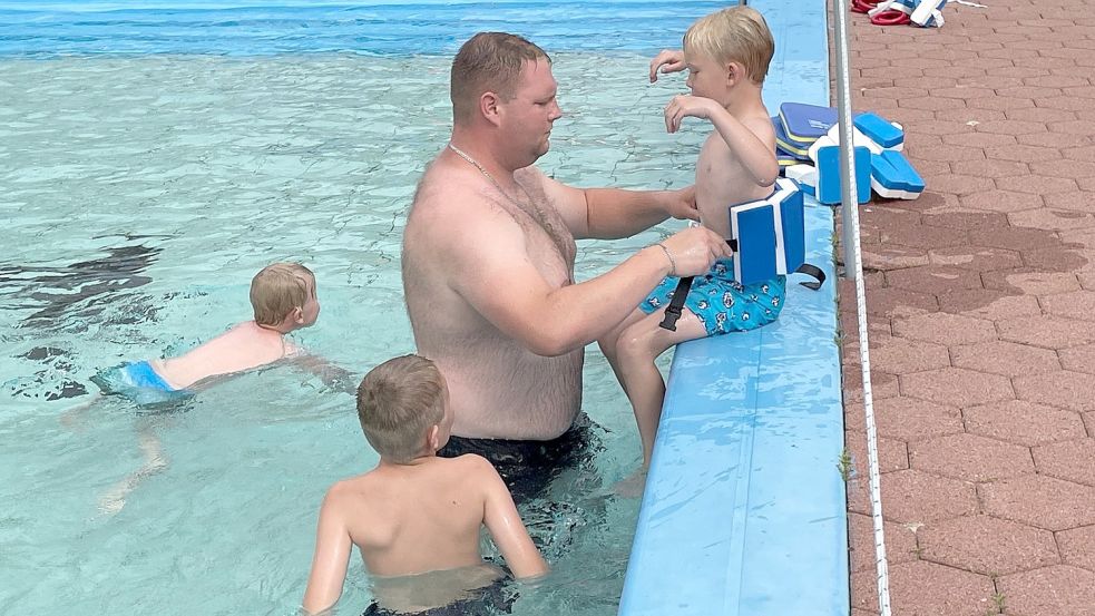 Heiko Wiese, Schwimmlehrer und Fachangestellter für Bäderbetriebe, bindet den Kindern Schwimmgürtel um. Foto: Boschbach