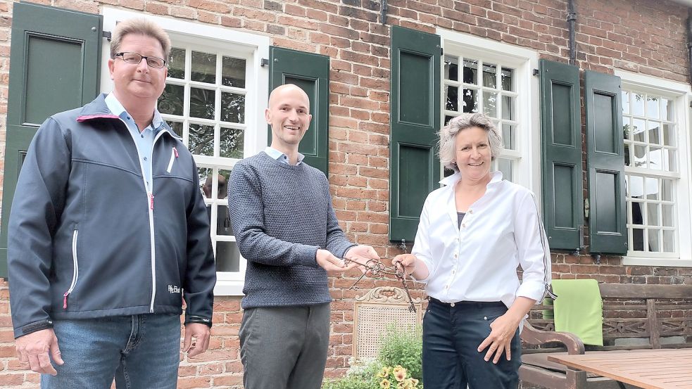Ulrike Rieks (von rechts) übergibt Christian Richter symbolisch den Schlüssel zum Café. Dass eine Gastronomie in Bingum bleibt, freut den Bingumer Ortsvorsteher Söhnke Eden. Foto: Vogt