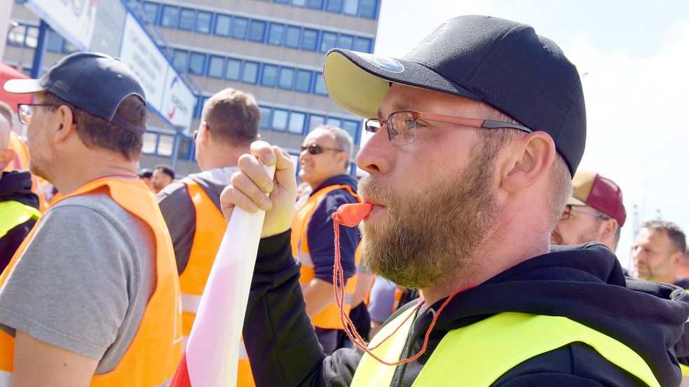 Protestierende Mitarbeiter der Logistik-Unternehmen BLG und Eurogate stehen am Donnerstag vor dem Werktor in Bremerhaven. Die Gewerkschaft Verdi hatte zu einem mehrstündigen Warnstreik aufgerufen. Im zweitgrößten deutschen Hafen beteiligten sich nach Gewerkschaftsangaben etwa 1000 Beschäftigte. Foto: Bahlo/DPA