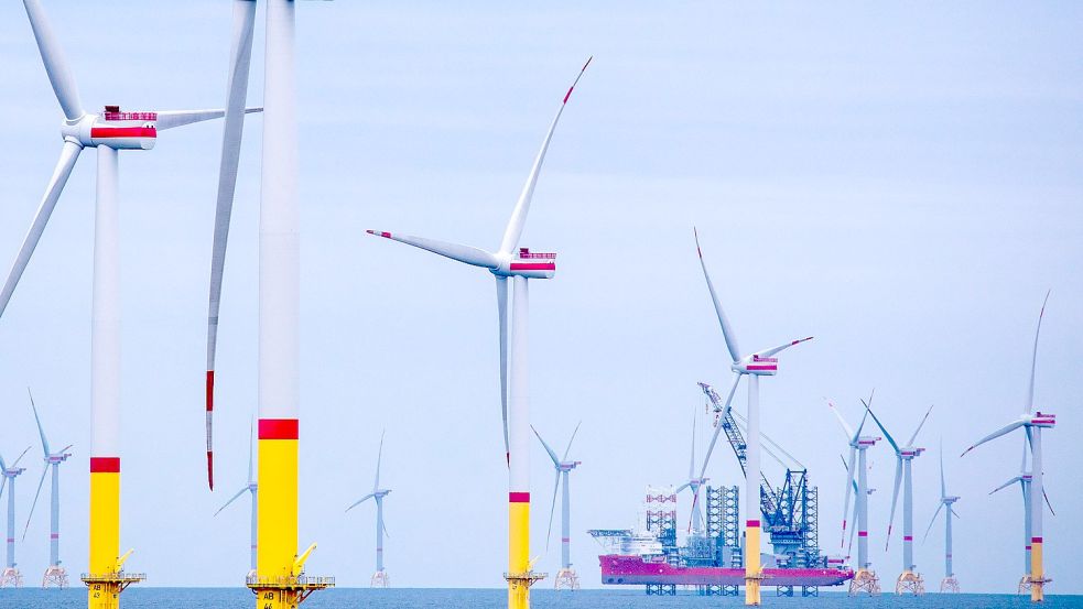 Ein Arbeitsschiff steht auf Stelzen zwischen Windrädern in einem Offshore-Park. Die Ausbauziele der Bundesregierung verschaffen der Industrie und Dienstleistungsunternehmen wie Wiking potenziell neue Aufträge. Foto: Jens Büttner/DPA