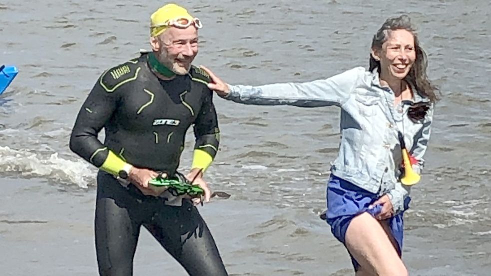 Frank Feldhus wurde in Harlesiel am Sonntag um kurz vor 16 Uhr noch im Wasser von seiner Ehefrau Carola Milde in Empfang genommen. Sie führte ihn zur großen „Fangemeinde“, die am Ufer auf den Oldenburger wartete. Foto: Siemens