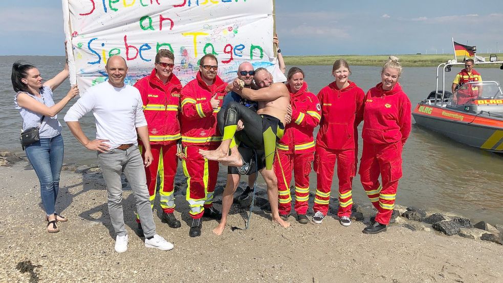 Frank Feldhus wurde bei seiner Tour von Kajak-Fahrer Matthias Lux aus Aurich (hält ihn im Arm) und der DLRG begleitet sowie unterstützt. Foto: Siemens