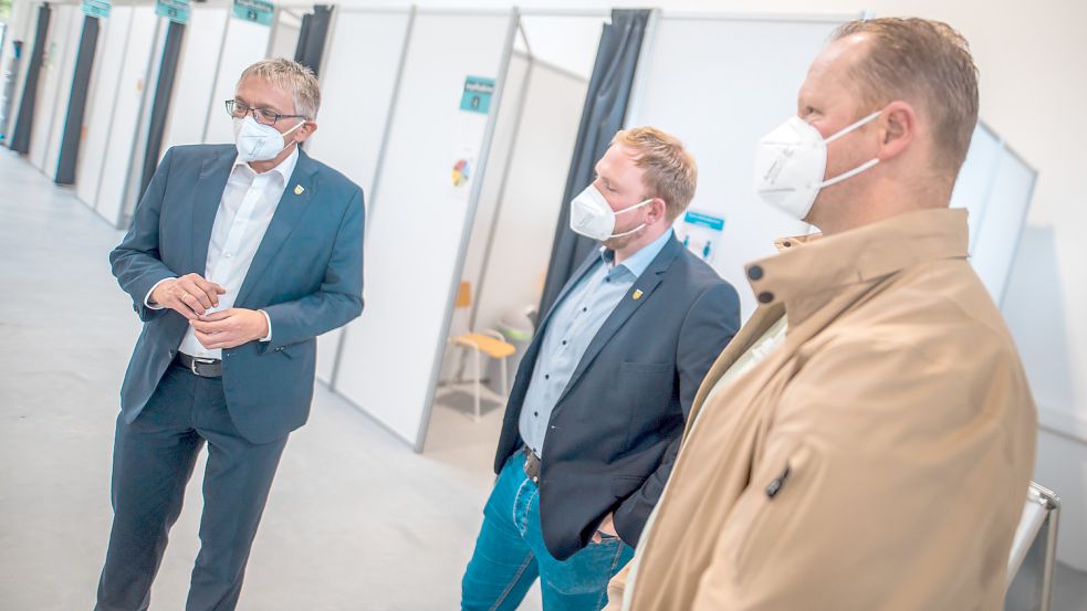 Landrat Olaf Meinen (von links), Sascha Regolin vom Kreis Aurich sowie der organisatorische Leiter des Impfzentrums, Norman Büchter, zeigten die neuen Impfkabinen.
