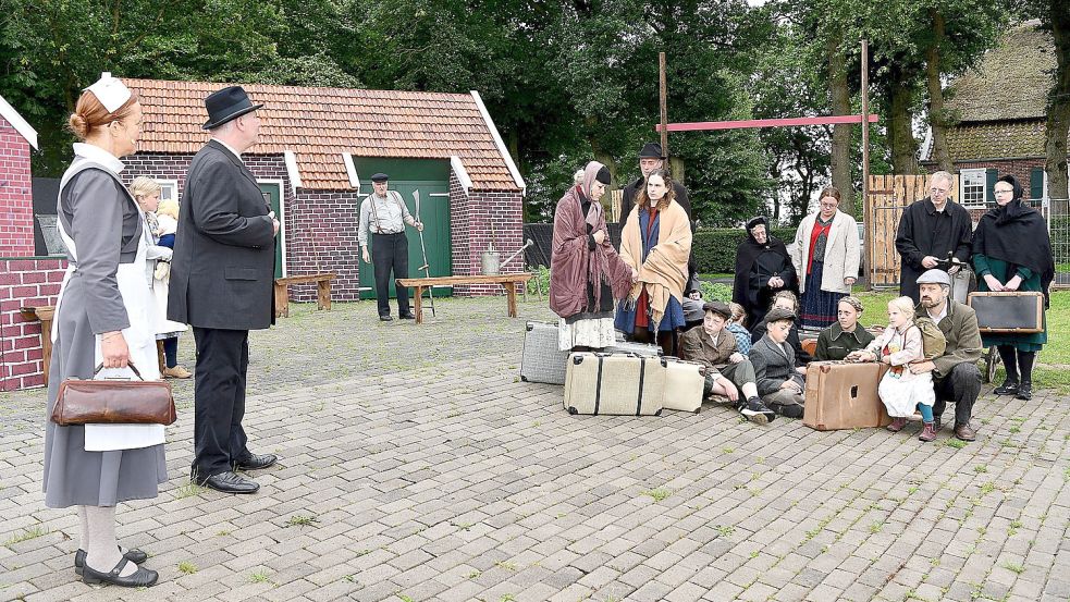 Gemeindeschwester Gerdes und Bürgermeister Neumann begrüßen die Flüchtlinge, die eben eingetroffen sind. Foto: Stromann