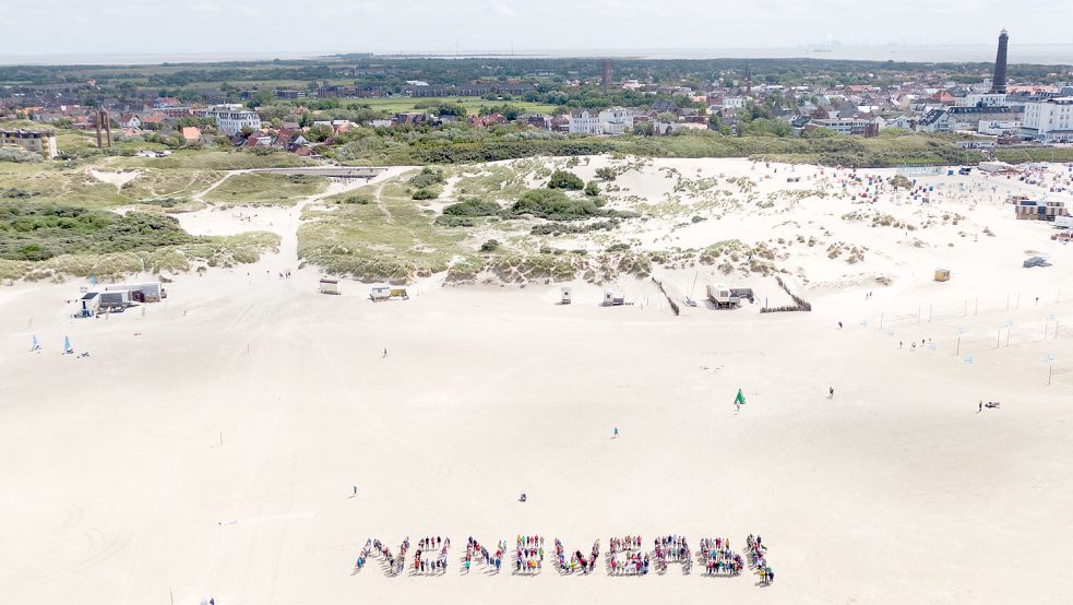 Vor dem Borkumer Panorama ist aus menschlichen Buchstaben die Forderung „NO NEW GAS!“ gebildet worden. Foto: Manz/Greenpeace