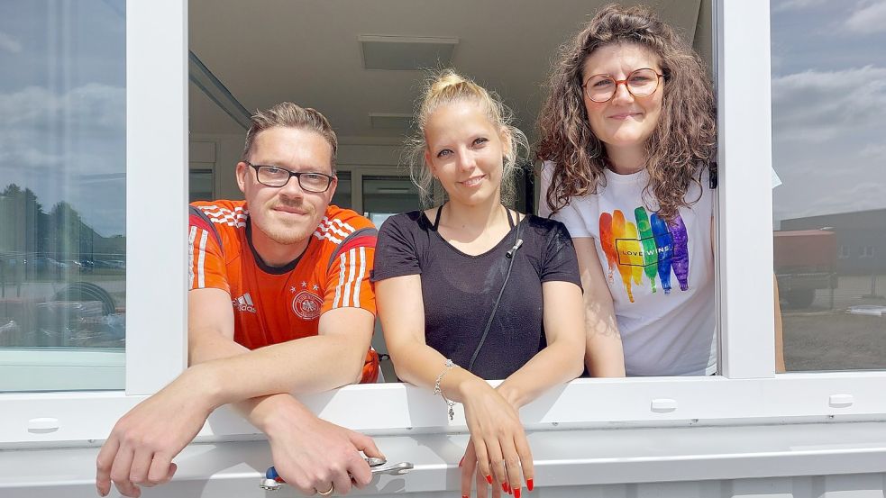 Lehrer Reiner Riemann (von links), Schulgründerin Dr. Katharina Lühring und Marlene Helms (ebenfalls Lehrkraft) schauen aus einem der Fenster der Klassenräume der neuen Schule in Emden. Foto: Hanssen