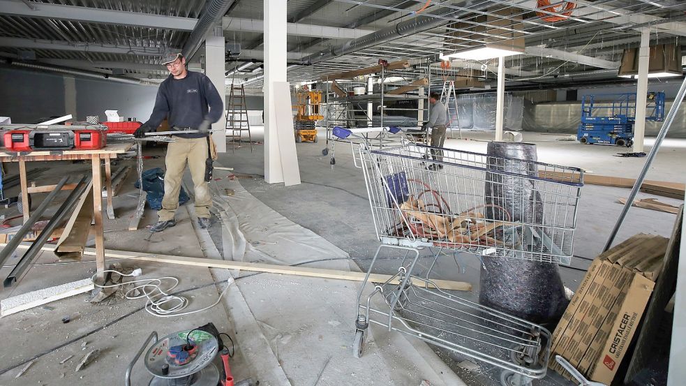 Wie ein Neubau soll der Combi-Markt nach der Sanierung aussehen. Monteure wie Mathias Schulte arbeiten daran. Foto: Böning