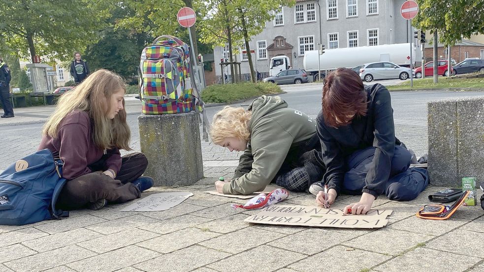 Jugendliche nehmen noch einen letzten Feinschliff an ihren Plakaten vor. Das Motto: Je auffälliger, desto besser.