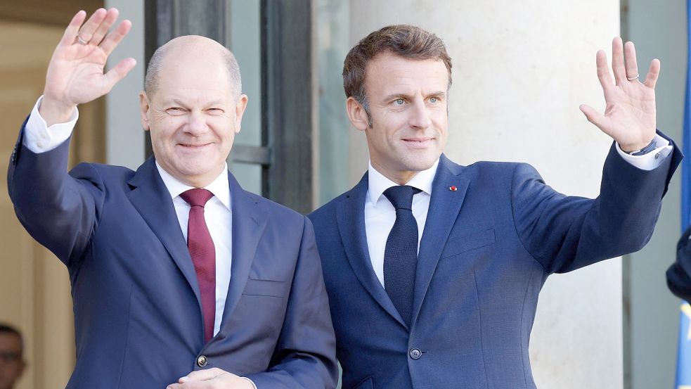 Frankreichs Präsident Emmanuel Macron (rechts) und Bundeskanzler Olaf Scholz (SPD) winken, als Scholz zu einem Mittagessen im Elysee-Palast in Paris eintrifft. Foto: Marin/AFP/DPA