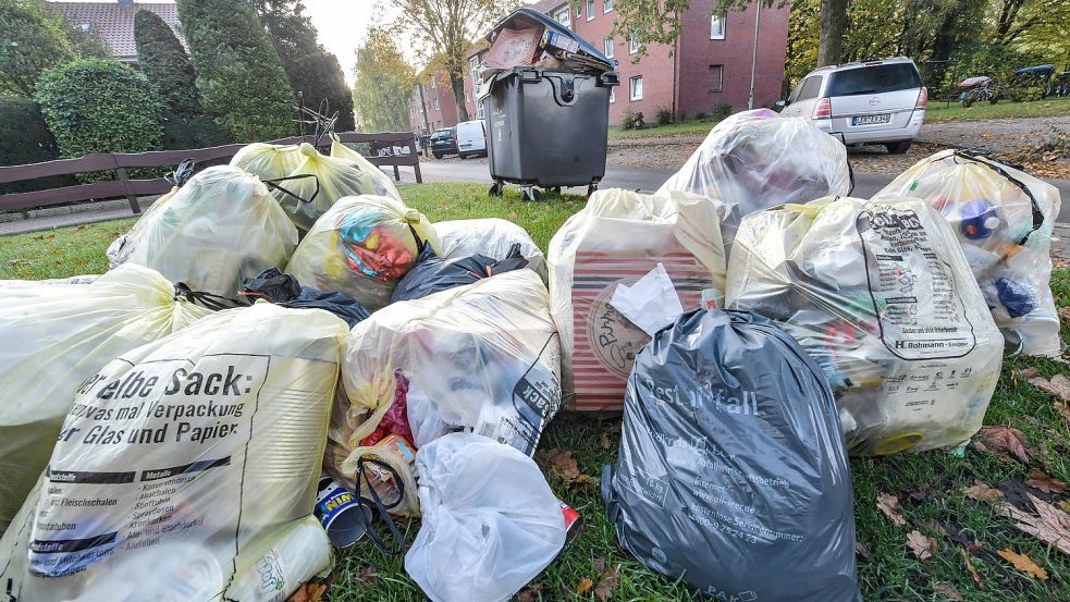 Im Vordergrund Rest- und Plastikmüll, der im Schreiberskamp abgeholt wird, im Hintergrund ein Müllcontainer für Altpapier, der über Monate nicht geleert wurde, weil er falsch befüllt ist. Foto: Ortgies