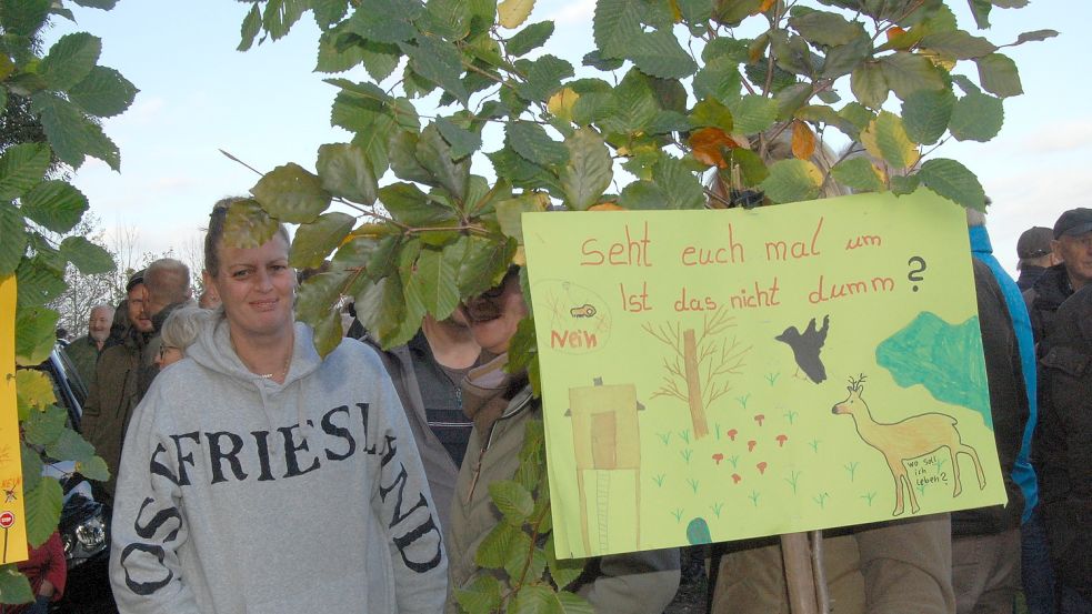 Einige Plakate sind an Zweigen befestigt.