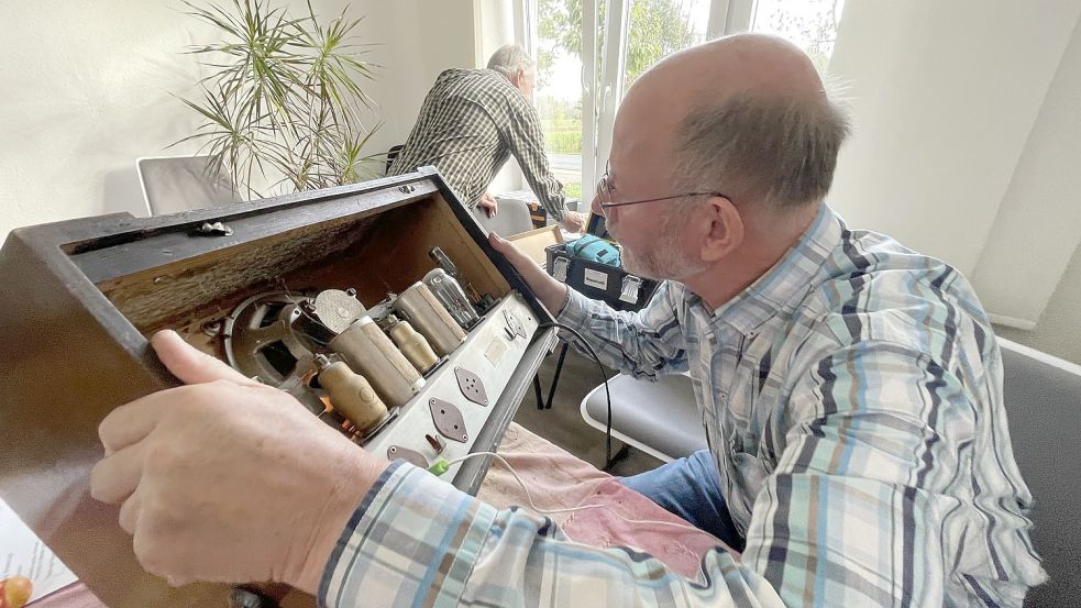 Heinz Hugen geht dem Defekt auf den Grund. „Das ist das älteste Röhrenradio, das ich je hatte“, sagt er begeistert. Foto: Päschel