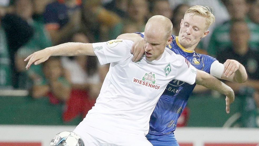 Im DFB-Pokal-Spiel gegen Werder Bremen (vorne Davy Klaassen) führte Nick Köster (hinten) Atlas Delmenhorst 2019 als Kapitän ins Weserstadion. Foto: Imago