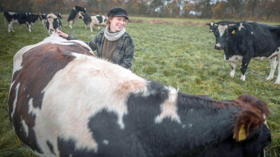Maren Osterbuhr krault ihre 14 Jahre alte Kuh Sissi auf der Weide. Diese Haltungsform ist der Strackholterin unglaublich wichtig. Fotos: Cordsen