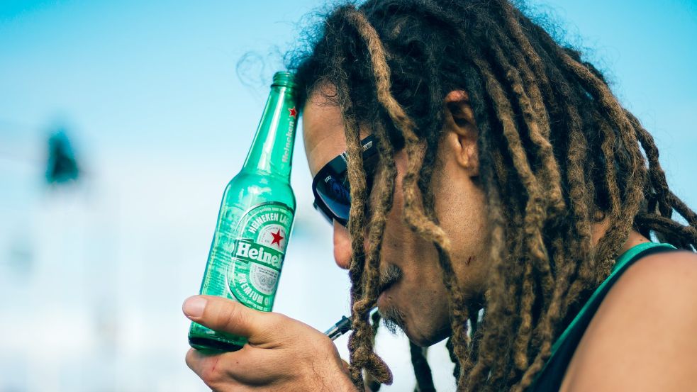 Joint in der einen Hand, Bier in der anderen: Das Rezept für einen entspannten Abend? Foto: Unsplash/Shot by Cerqueira