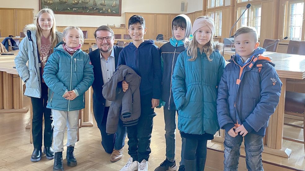 Ein paar Kinder haben sich mit Tim Kruithoff für ein Foto zusammengestellt.