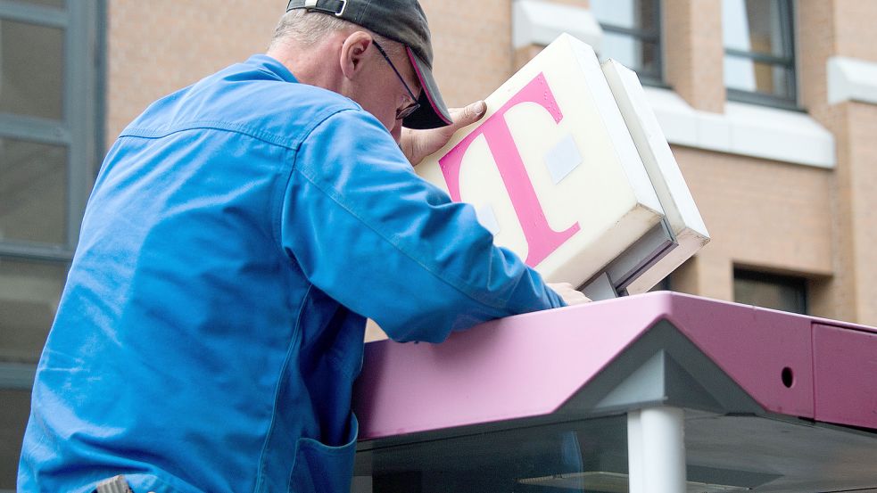 Ein Arbeiter baut eine Telefonzelle der Deutschen Telekom ab. Nun ist es in Ostfriesland bald völlig aus mit den Telefonen im öffentlichen Raum. Foto: DPA